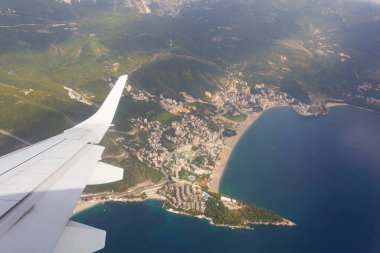 Karadağ ve Avrupa 'nın bulutları, kıyıları ve dağları üzerinde uçan uçağın kanatları