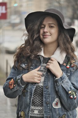 Güzel çekici kız bir şehir sokak arka plan üzerinde siyah bir şapka