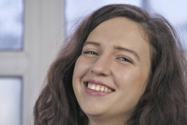 Kış cam kenarında oturan kırmızı elbiseli güzel çekici kız