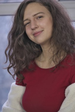 Kış cam kenarında oturan kırmızı elbiseli güzel çekici kız