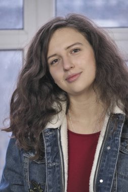 Kış cam kenarında oturan bir sıcak mavi kot ceket çekici kız güzel