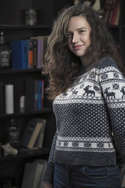 Yün kazak kitap rafı arka plan üzerinde çekici kız güzel