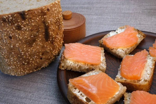 Pequenos sanduíches em pão caseiro com manteiga e peixe vermelho — Fotografia de Stock