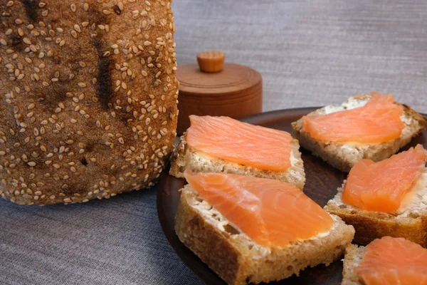 Pequenos sanduíches em pão caseiro com manteiga e peixe vermelho — Fotografia de Stock