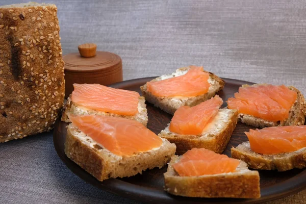Pequenos sanduíches em pão caseiro com manteiga e peixe vermelho — Fotografia de Stock