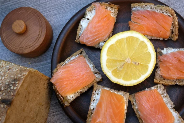 Kleine broodjes op zelfgebakken brood met boter en rode vis — Stockfoto