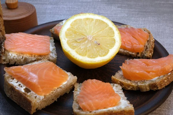 Kleine broodjes op zelfgebakken brood met boter en rode vis — Stockfoto