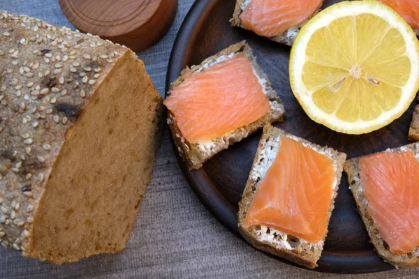 Pequenos sanduíches em pão caseiro com manteiga e peixe vermelho — Fotografia de Stock