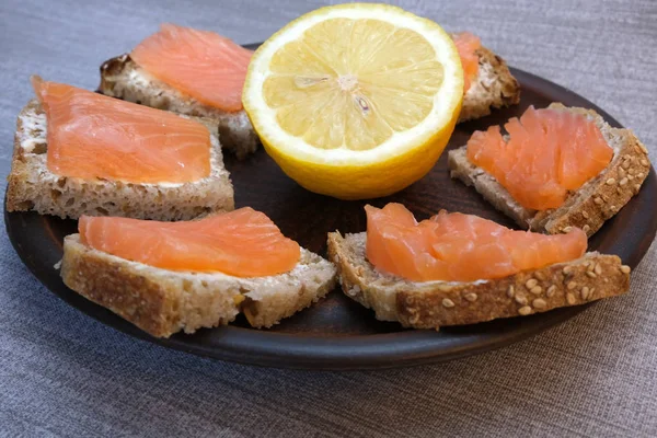 Pequeños sándwiches de pan casero con mantequilla y pescado rojo —  Fotos de Stock