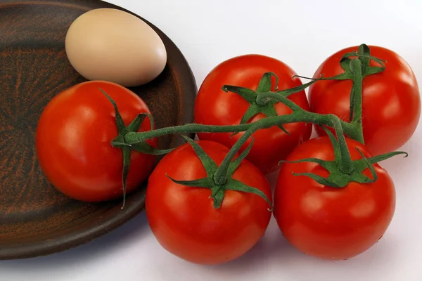 Cinco tomates maduros vermelhos e um ovo — Fotografia de Stock