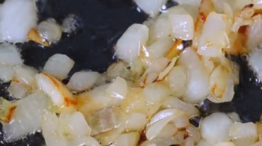 Beyaz soğan olmayan bir sopa teflon ızgara üzerinde zeytinyağı ile kırmızı taze domates ile haşlanmış küçük parçalar halinde doğranmış, video klip yakın çekim zoom ve kamera hareketi kullanarak çekim