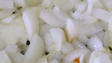 Beyaz soğan olmayan bir sopa teflon ızgara üzerinde zeytinyağı ile kırmızı taze domates ile haşlanmış küçük parçalar halinde doğranmış, video klip yakın çekim zoom ve kamera hareketi kullanarak çekim