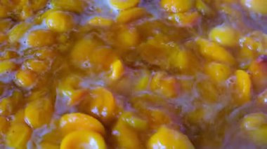 Şeker ile kendi suyu içinde çekirdeksiz meyve yarıya gelen kayısı reçel pişirme yakın çekim eklendi