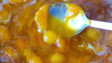 Şeker ile kendi suyu içinde çekirdeksiz meyve yarıya gelen kayısı reçel pişirme yakın çekim eklendi