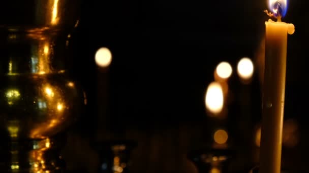 微妙的教堂蜡烛燃烧在东正教教堂附近的圣像在黑暗中特写 拍摄使用变焦和移动相机 — 图库视频影像