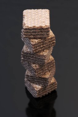 Küçük kare tatlı waffle parçaları ile çikolata dolgulu siyah arka plan yakın çekim makro fotoğraf