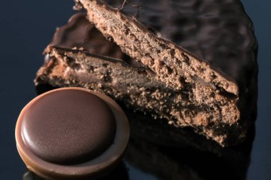 Fındıklı çikolatalı şekerler arka plandaki karanlık aynada makro fotoğrafa yakın çekim yapıyor.