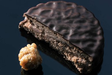 Fındıklı çikolatalı şekerler arka plandaki karanlık aynada makro fotoğrafa yakın çekim yapıyor.