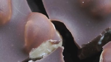 Market videosu arka planda fındıklı siyah çikolata kamera önünde zum efektiyle makro çekim yapıyor.