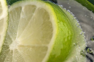 Bir bardak soda ve limon dilimleri yakın çekim makro fotoğrafçılık ürünü arka planı.