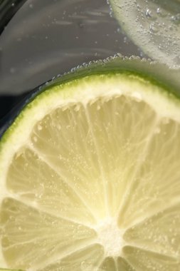 Bir bardak soda ve limon dilimleri yakın çekim makro fotoğrafçılık ürünü arka planı.