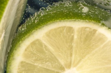 Bir bardak soda ve limon dilimleri yakın çekim makro fotoğrafçılık ürünü arka planı.