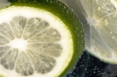 Bir bardak soda ve limon dilimleri yakın çekim makro fotoğrafçılık ürünü arka planı.