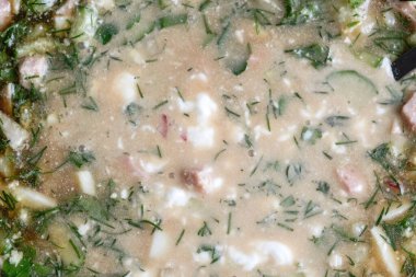 Sosisli sebze salatası, haşlanmış yumurta ve patates, salatalık, turp, maydanoz ve dereotlu. Ekmek kvass ve ekşi krema ile soğuk bir ilk yemek olarak kullanılır..