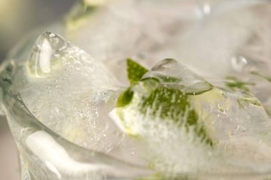 Limonata dilimlenmiş limonata ve şeffaf terli cam bardakta buz yakın çekim makro fotoğraf.