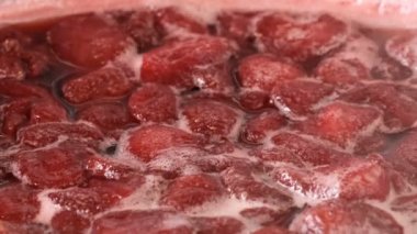 Çilek reçeli açık bir kasede pişirilir yakın çekim makro video zoom ve kamera hareketi gıda arka planını uygular