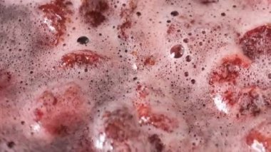 Çilek reçeli açık bir kasede pişirilir yakın çekim makro video zoom ve kamera hareketi gıda arka planını uygular