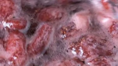 Çilek reçeli açık bir kasede pişirilir yakın çekim makro video zoom ve kamera hareketi gıda arka planını uygular
