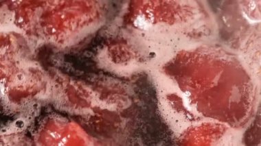 Çilek reçeli açık bir kasede pişirilir yakın çekim makro video zoom ve kamera hareketi gıda arka planını uygular