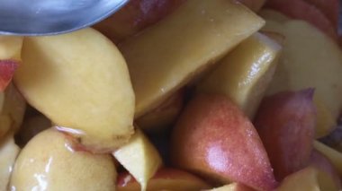 Evde şeftali reçeli pişiriyorum meyve suyu şurubunda açık bir tavada yakın çekim makro çekim gıda taşınıyor.