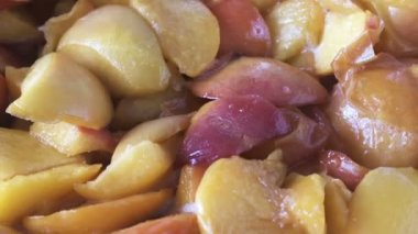 Evde şeftali reçeli pişiriyorum meyve suyu şurubunda açık bir tavada yakın çekim makro çekim gıda taşınıyor.