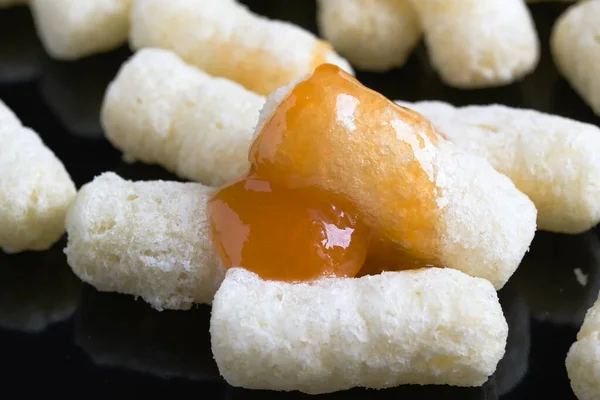 Mais Luft Sticks Puderzucker Mit Aprikosenmarmelade Auf Schwarzer Spiegeloberfläche Makrofotografie — Stockfoto