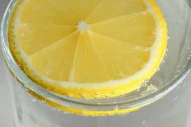 Yuvarlak limon dilimi, gevşek soda, ferahlatıcı limonata, yakın plan makro fotoğraf, vejetaryen arka plan.