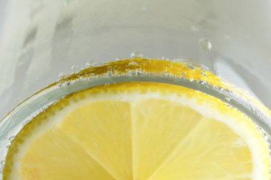 Yuvarlak limon dilimi, gevşek soda, ferahlatıcı limonata, yakın plan makro fotoğraf, vejetaryen arka plan.