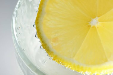 Yuvarlak limon dilimi, gevşek soda, ferahlatıcı limonata, yakın plan makro fotoğraf, vejetaryen arka plan.