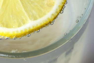 Yuvarlak limon dilimi, gevşek soda, ferahlatıcı limonata, yakın plan makro fotoğraf, vejetaryen arka plan.