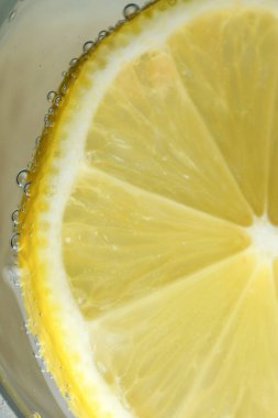 Yuvarlak limon dilimi, gevşek soda, ferahlatıcı limonata, yakın plan makro fotoğraf, vejetaryen arka plan.