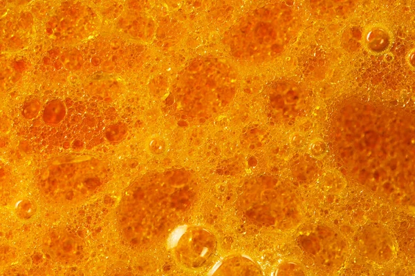 Petrol ve yağ çözücüden su kabarcıkları içeren soyut kırmızı ve sarı arkaplan makro fotoğrafçılığı kapat