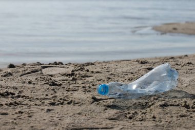 plaj kum üzerinde parçalanmış pet tek kullanımlık plastik şişe. Plastik kirliliği