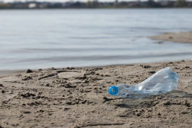 plaj kum üzerinde parçalanmış pet tek kullanımlık plastik şişe. Plastik kirliliği