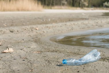 plaj kum üzerinde parçalanmış pet tek kullanımlık plastik şişe. Plastik kirliliği