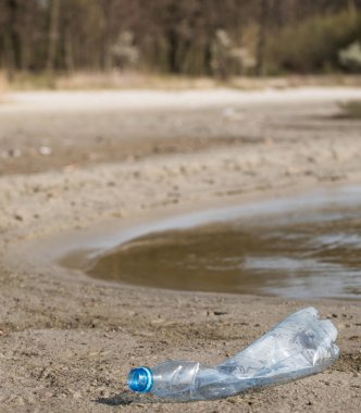plaj kum üzerinde parçalanmış pet tek kullanımlık plastik şişe. Plastik kirliliği