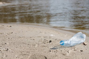 plaj kum üzerinde parçalanmış pet tek kullanımlık plastik şişe. Plastik kirliliği