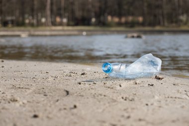 plaj kum üzerinde parçalanmış pet tek kullanımlık plastik şişe. Plastik kirliliği