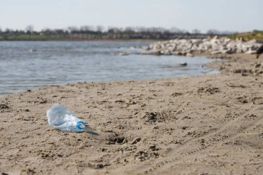 plaj kum üzerinde parçalanmış pet tek kullanımlık plastik şişe. Plastik kirliliği