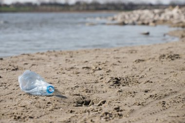 plaj kum üzerinde parçalanmış pet tek kullanımlık plastik şişe. Plastik kirliliği